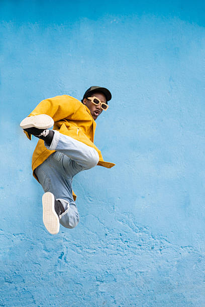 istock Young handsome afro man jumping while kicking out one leg 2225134702