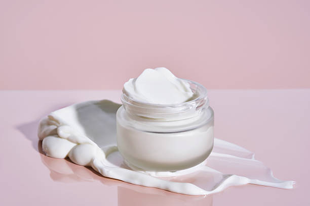 istock An open jar of cream with its texture on a pink background. 2225136081