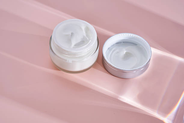 istock An open jar of cream with its texture on a pink background. 2225136140