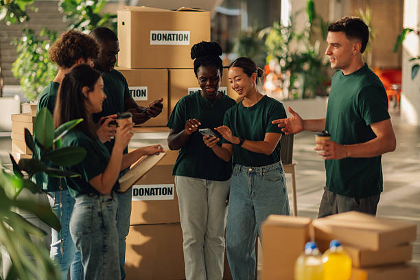 istock Volunteers organizing donations using mobile phone and checklist 2225137349