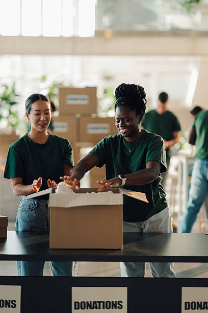 istock Volunteers packing donations in cardboard boxes at community center 2225137412