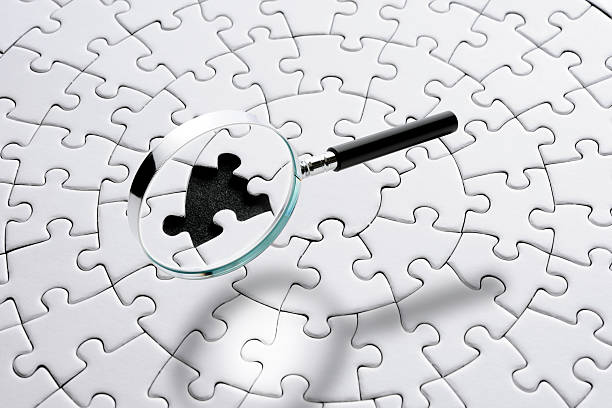 istock Magnifying glass floating in mid-air over the blank jigsaw puzzle 2225137494