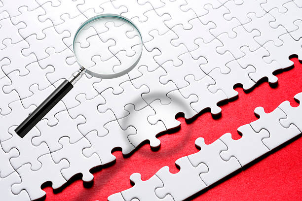 istock Magnifying glass floating in mid-air over the blank jigsaw puzzle 2225137498