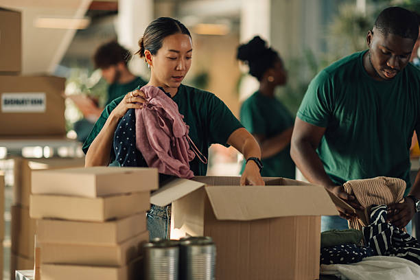 istock Volunteers sorting clothes and canned food for donation 2225137561