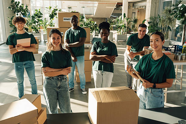 istock Volunteers smiling while organizing donations in cardboard boxes 2225137563