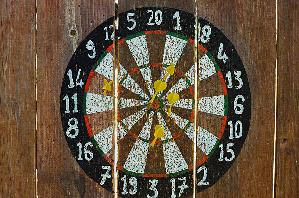 istock Rustic Dartboard On Wooden Surface With Yellow Darts Scored 2225137748