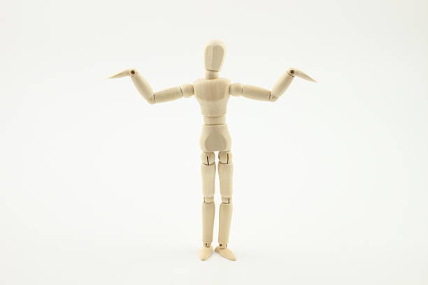 Wooden modelling dummy holding up an artists drawing pencil above its head on a white background.