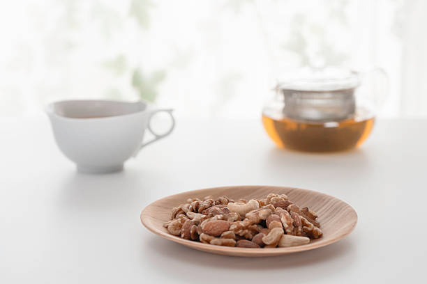 Mixed nuts and hot tea on a white table