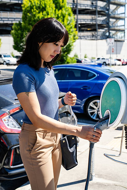 istock Millennial  at Electric Vehicle Charging Station 2225144411