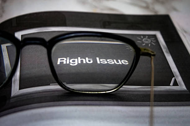 Fashion news concept. Eyeglasses , clock and heap of magazines