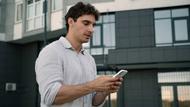 istock Caucasian man going walking using mobile phone smartphone online social media technology networks internet employee male guy businessman city outdoors gadget holding device cellphone worker business 2225146046
