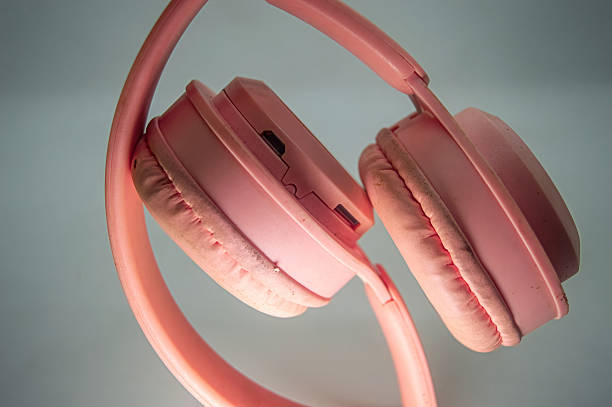 istock Worn pink headphones with soft cushions placed on a white surface, highlighting texture, everyday use, and personal audio gear. Ideal for tech, music, or cleaning themes 2225146681