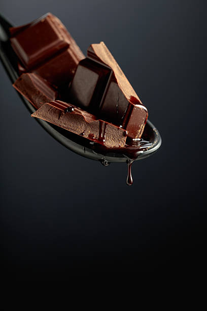 istock Melting pieces of bitter chocolate on a black background. 2225150093
