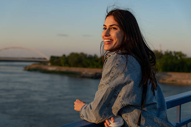 istock Young woman enjoying sunset view on bridge 2225153030