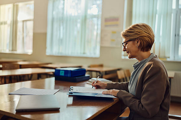 istock Female teacher writing her plans in the classroom. 2225153631