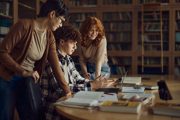 istock Group of high school students using laptop in library. 2225153791