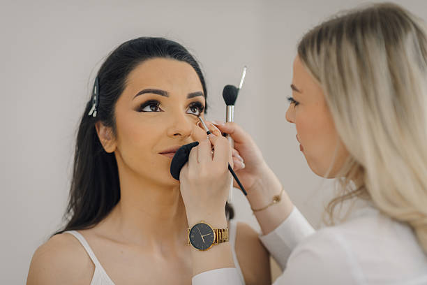 istock Professional makeup artist applying makeup on bride's face 2225156561