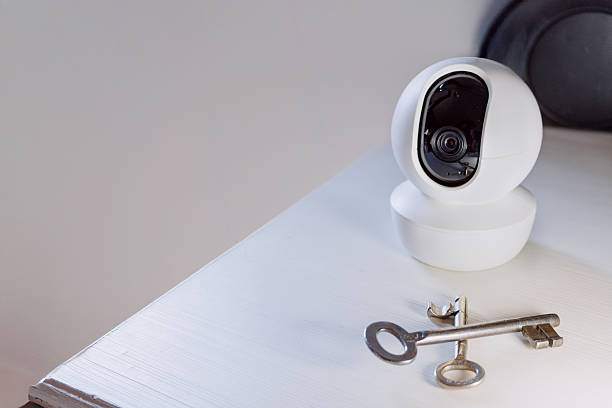 istock Security Camera with Two Crossed Keys on Furniture Surface 2225164146