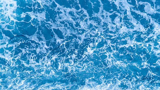 istock Breaking blue ocean waves from above, creating intricate white foam patterns 2225166117