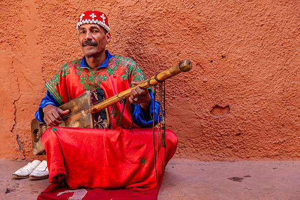 Moroccan street musician in traditional costume on Djemaa el Fna square, Marrakech, Morocco. Djemaa el Fna is a heart of Marrakesh's medina quarter.