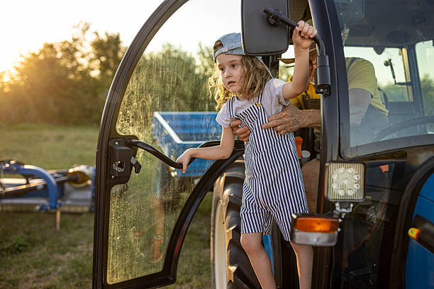 A boy is playing on a red tractor in Vinnytsia, Vinnytsia Oblast, Ukraine