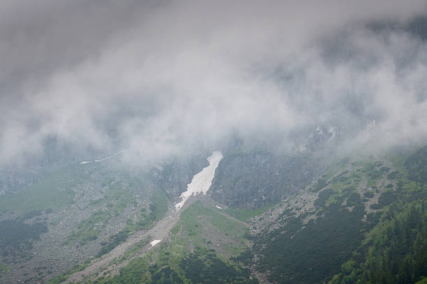 Mountain peaks in clouds, rainy weather.