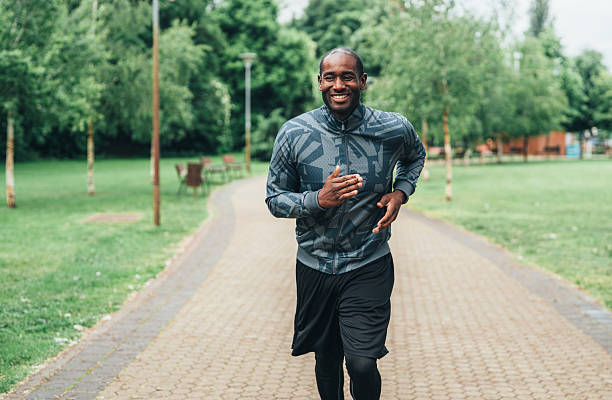 istock Smiling man jogging outdoors in the park. 2225169423