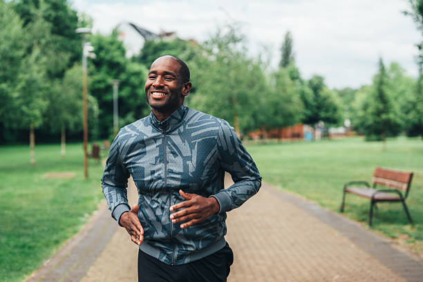 istock Smiling man jogging outdoors in the park. 2225169424