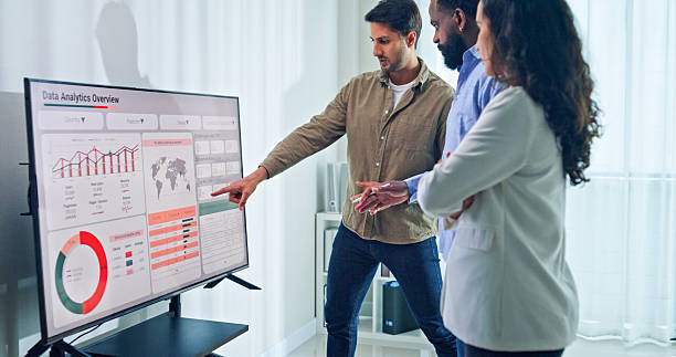 istock Group of business professionals meeting reviewing global data analytics discussing data analytics during a presentation, discussing strategy and growth standing at the office. Finance meeting concept. 2225172908