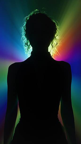 Silhouette of woman in rainbow light burst