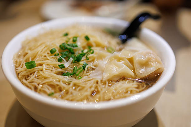 Wonton noodle soup served in white bowl
