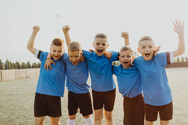 istock Junior soccer team posing together on the field in blue uniforms 2225178900