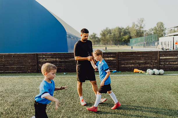 istock Coach instructing junior football team 2225179512