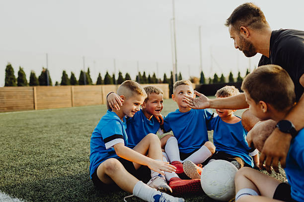 istock Coach instructing junior football team 2225179796