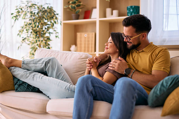 istock Young couple relaxing on sofa at home enjoying time together 2225179868