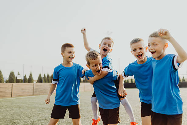 istock Junior soccer team posing together on the field in blue uniforms 2225181286