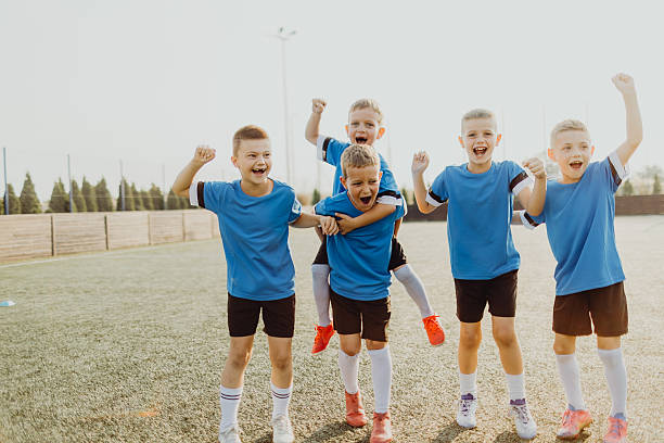 istock Junior soccer team posing together on the field in blue uniforms 2225181463