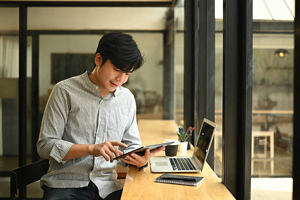 istock Modern freelancer uses smart devices in a relaxed cafe setting, balancing work and comfort, Digital nomad lifestyle 2225183488