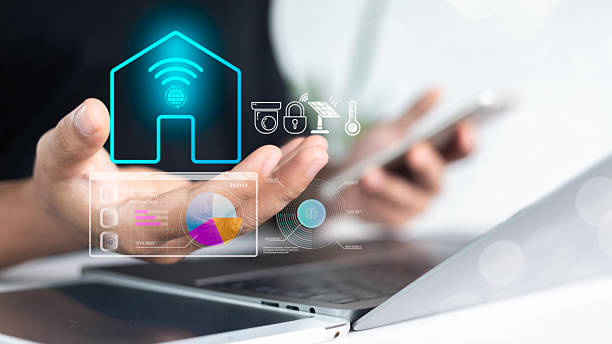 istock Hand using a smartphone with a holographic smart home interface. Concept of IoT, home automation, digital control system, and smart technology integration. 2225184075