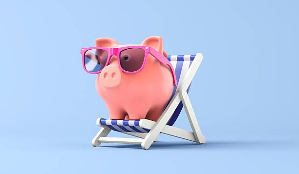 istock Pink piggy bank sat in a deckchair 2225184292