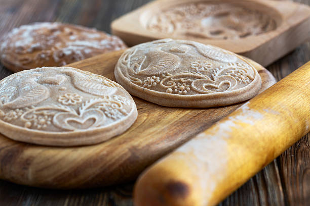 Handcrafted wooden stamps with intricate designs, used for imprinting patterns on baked goods, showcasing traditional culinary artistry.