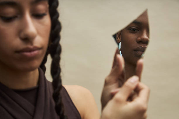 Young and beautiful woman looking at herself in the mirror.