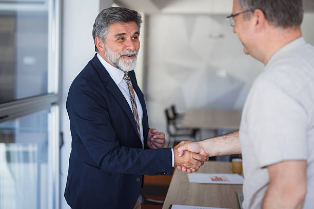 istock Two senior businessmen shaking hands in modern office 2225186902
