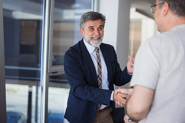 istock Two mature businessmen shaking hands in modern office 2225186908
