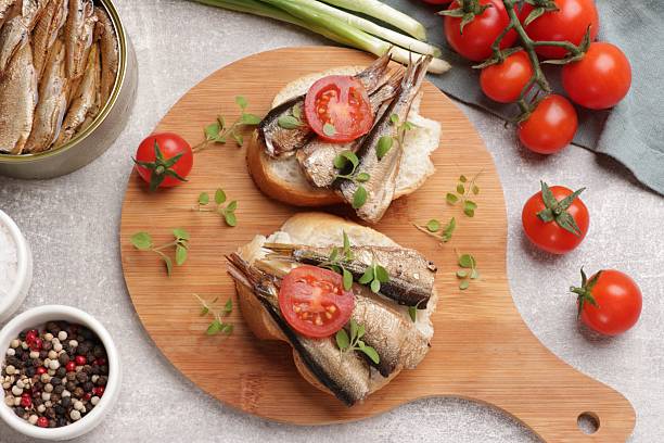 istock Delicious sandwiches with sprats served in grey table, top view 2225187472