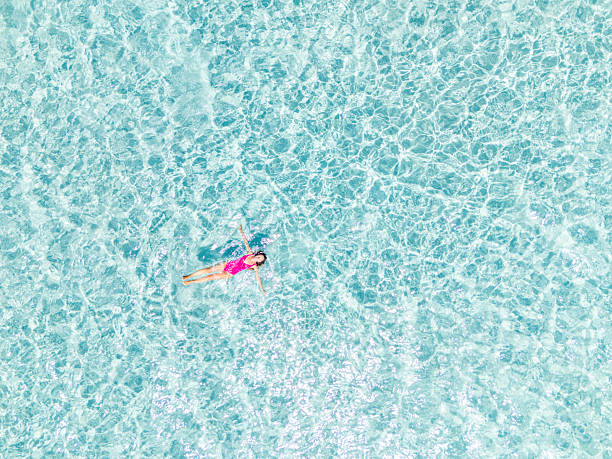 istock Person Floating Alone in Clear Blue Water 2225188384