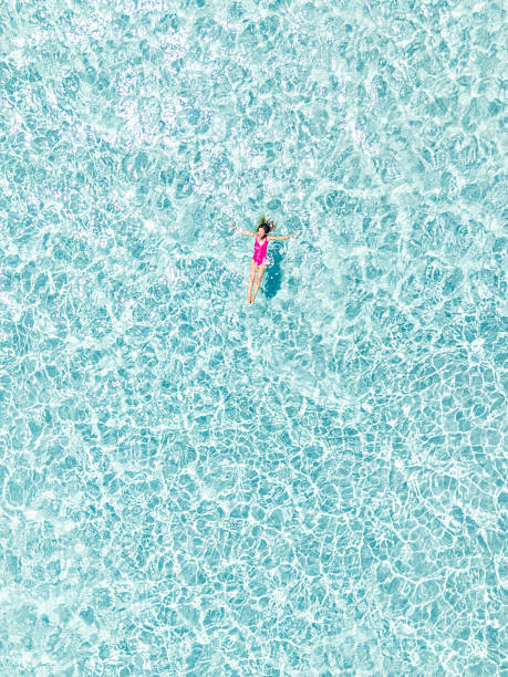 istock Woman Floating Relaxed in Clear Blue Water 2225188621
