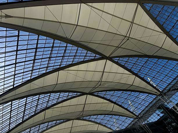 Munich, Germany - May 12, 2025: The glass and metal ceiling structure over the public square between Terminal 1 and Terminal 2 at Munich Airport.