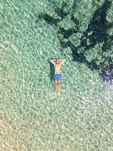 istock Man Relaxing in Clear Shallow Tropical Water 2225190793