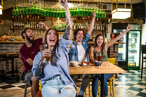 istock Group of friends cheering while watching soccer in a pub 2225192755